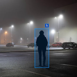 Pelco Security Cameras surveillance footage showing AI capture of person walking in a parking lot at night.