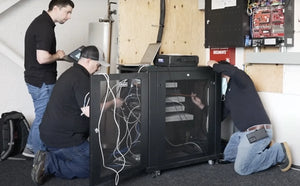 Electricians installing hardware switches for security cameras.